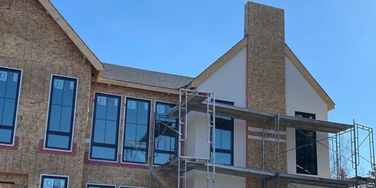 Edmonton home exterior with wood framing exposed and scaffolding erected in preparation for stucco installation