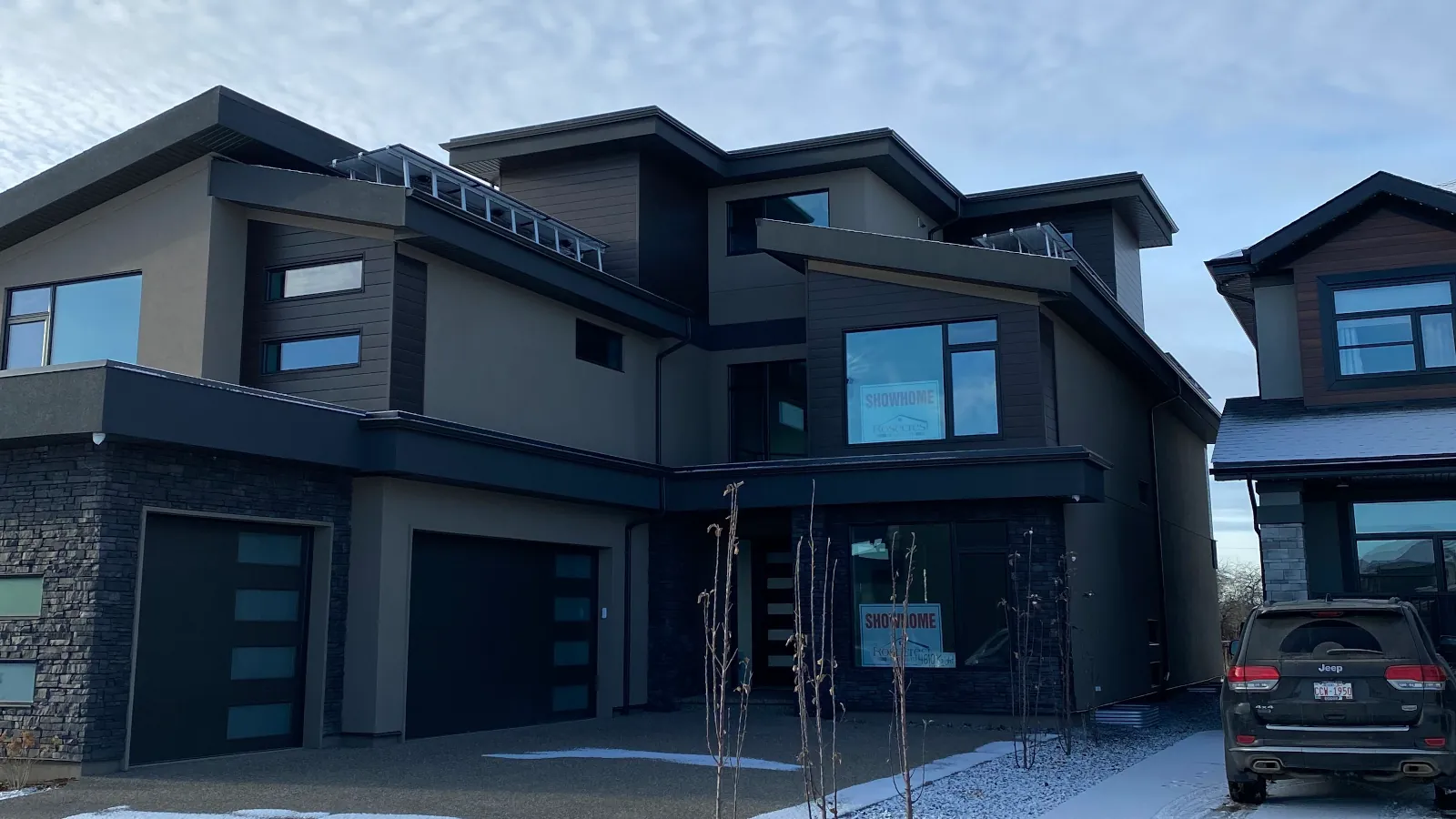 Long side profile of a residential building showing a clean and consistent beige acrylic stucco finish from roofline to foundation.