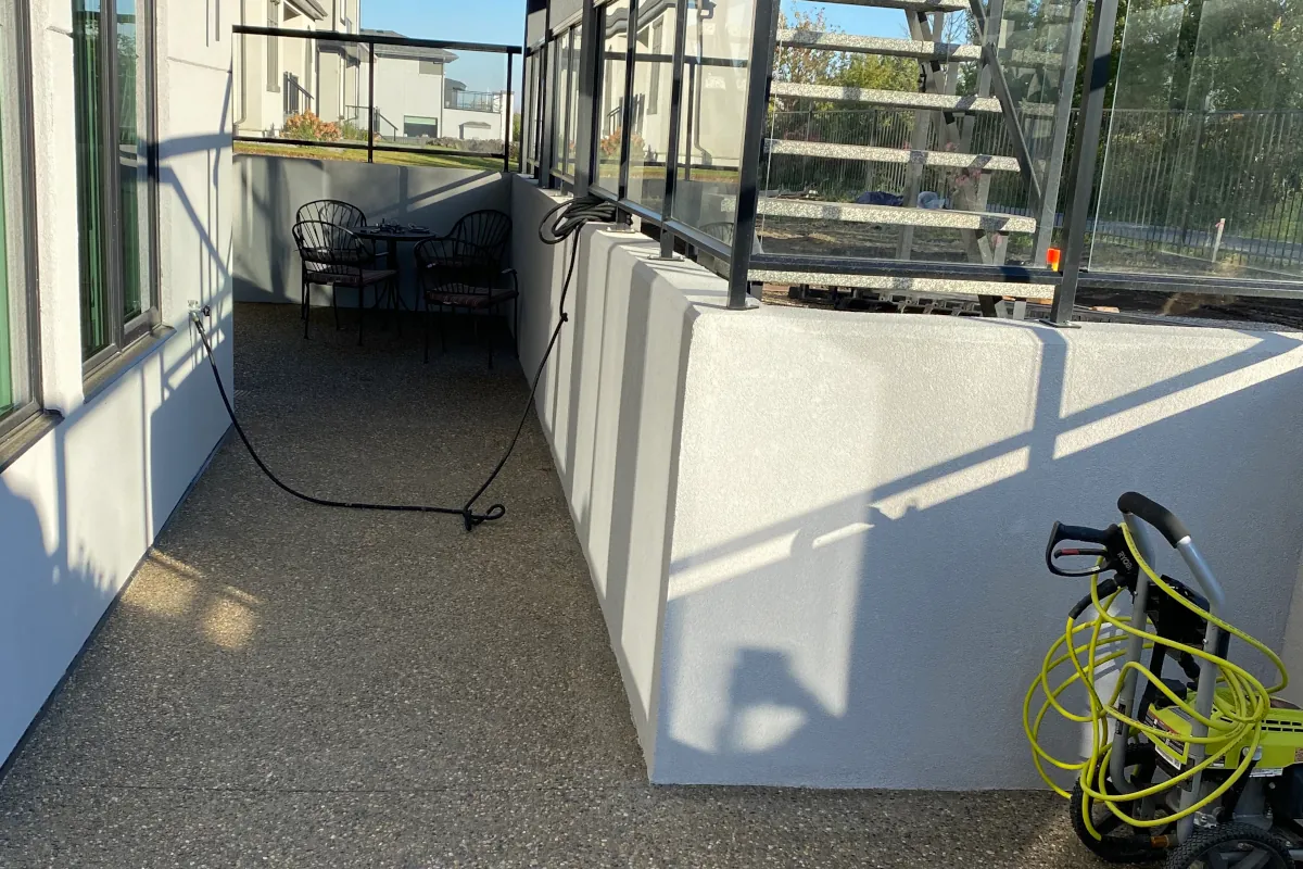 Smooth grey parging finish applied to custom retaining walls on a modern Edmonton home exterior.