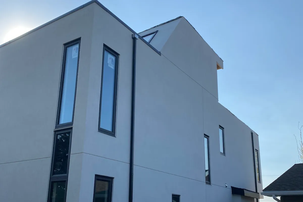 Clean off-white smooth stucco finish on a modern multi-level residential exterior in Fort Saskatchewan.